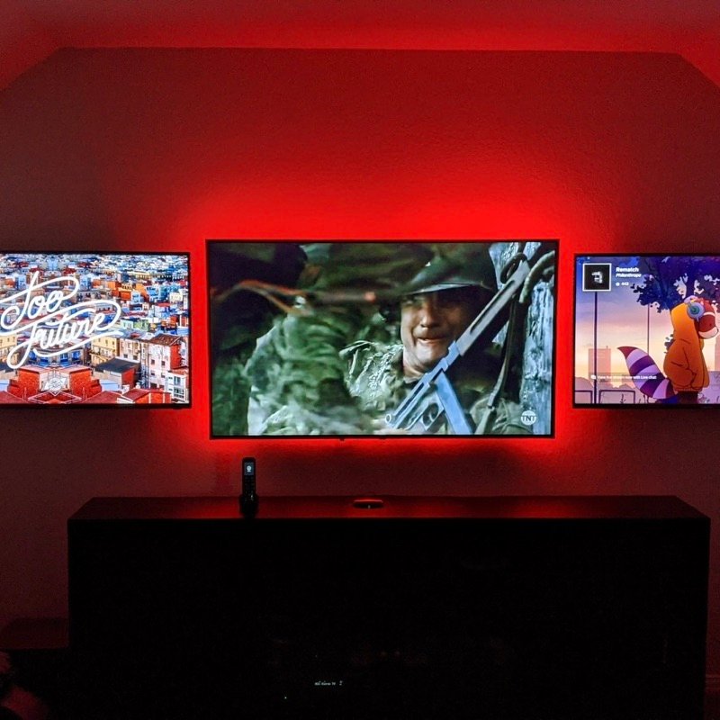 Triple TV wall mounting setup with red LED backlighting